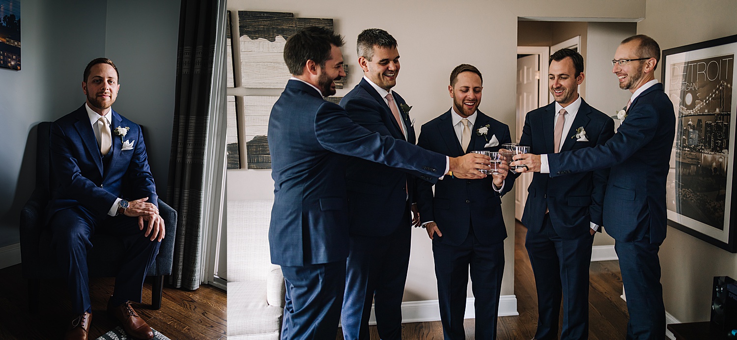 groomsmen clinking beer glasses in blue suit coats and blush pink wedding ties 