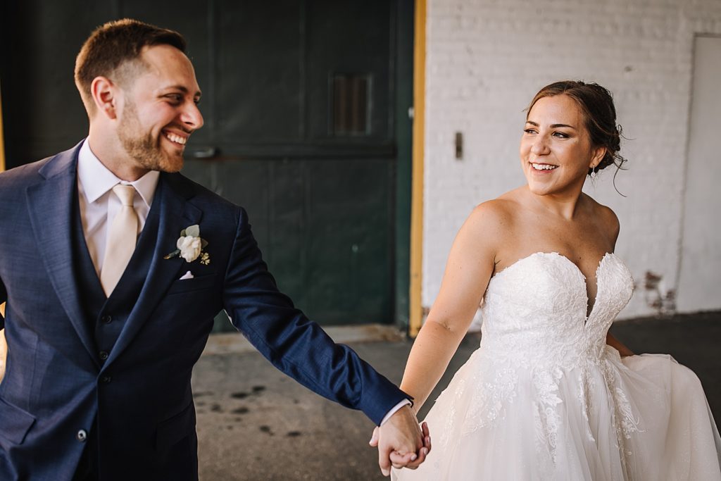 bride and groom holding hands in downtown Detroit after wedding ceremony 